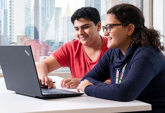 An image of students looking at a computer.